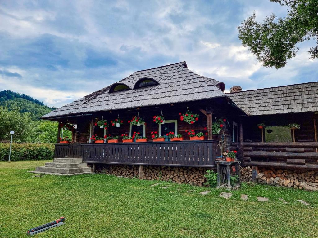 a house with flowers on it in a yard at Căsuța “La Bubuțu” in Câmpulung Moldovenesc