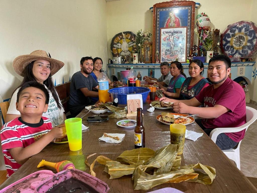 un grupo de personas sentadas alrededor de una mesa comiendo comida en LÍZU Tu casa en un pueblo zapoteca, en Teotitlán del Valle