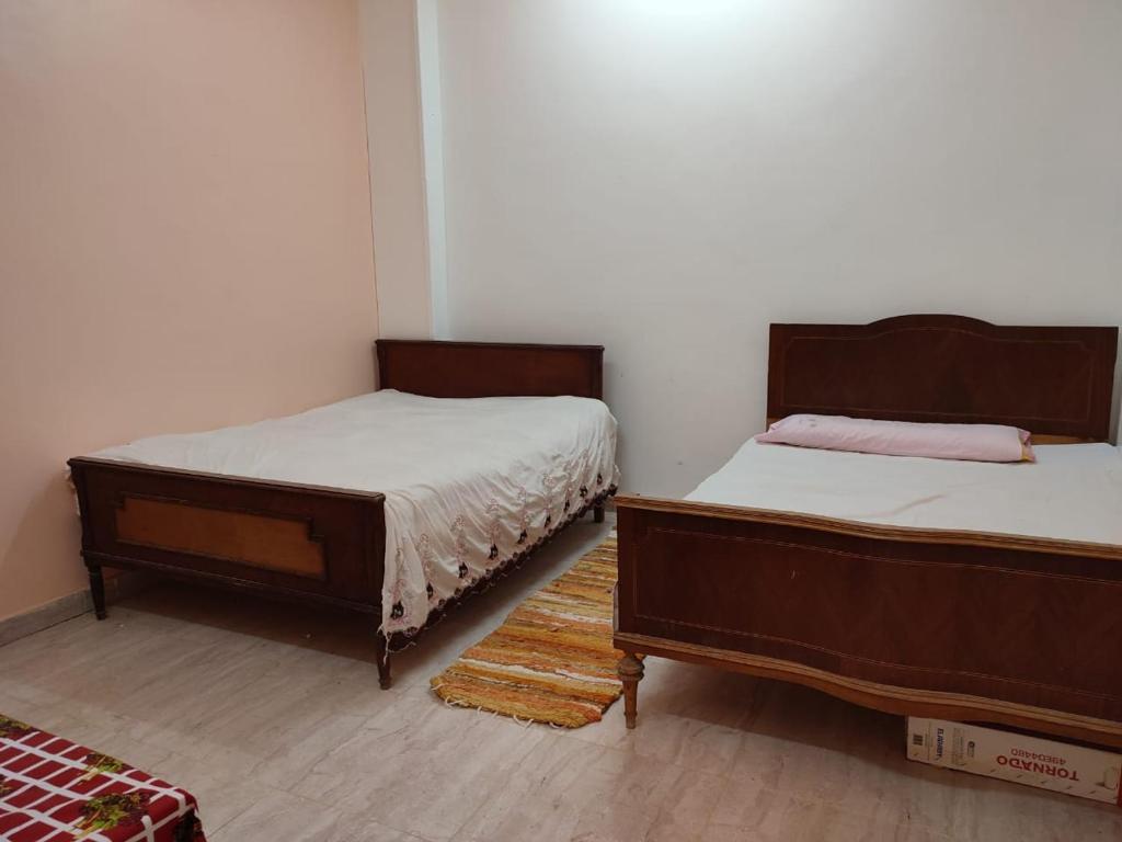 two beds sitting in a room with at Best appartment in Quseir