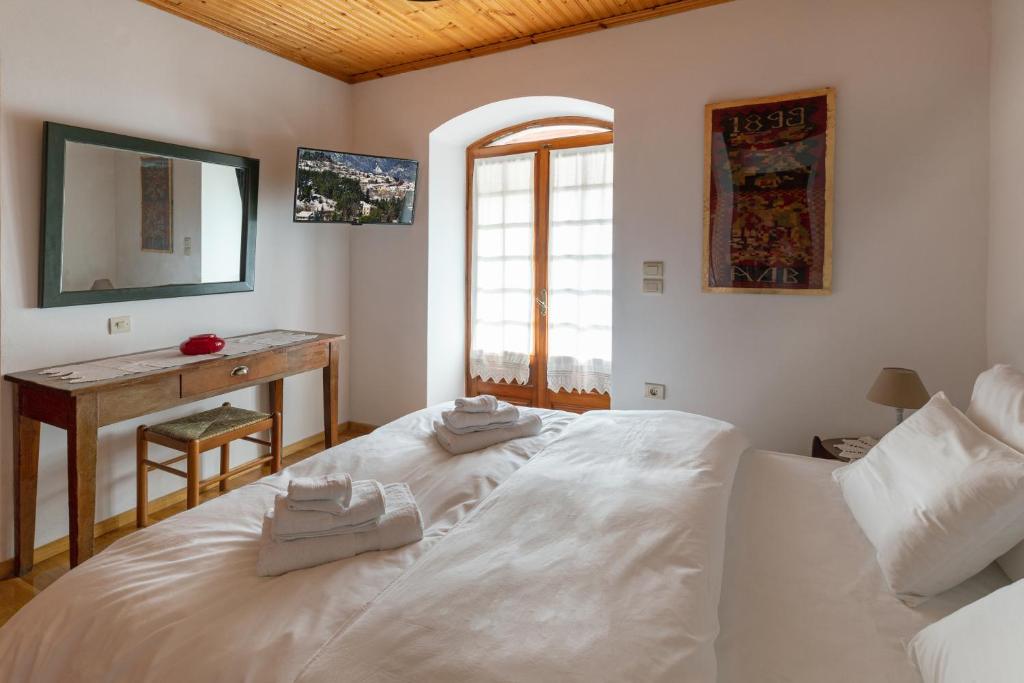 a bedroom with two white beds and a desk at Kallisti Vitina Home in Vytina
