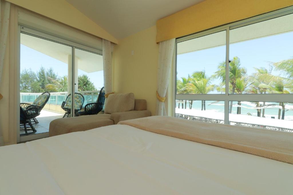 ALIZE CUMBUCO في كومبوكو: غرفة نوم مع سرير وإطلالة على المحيط