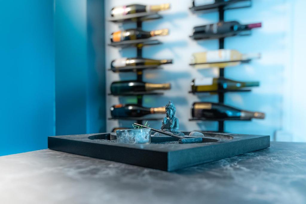 a table with a shelf of wine bottles at Grande Chambre meublé chez l'habitant in Coignières