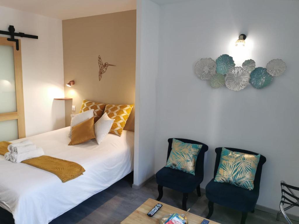1 dormitorio con 2 camas y 2 sillas azules en Studio Cosy Bronze - Cosy & Cocon en Mulhouse
