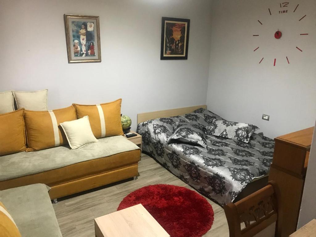 ein Wohnzimmer mit einem Sofa und einem Bett in der Unterkunft JANO apartment Korce in Korçë