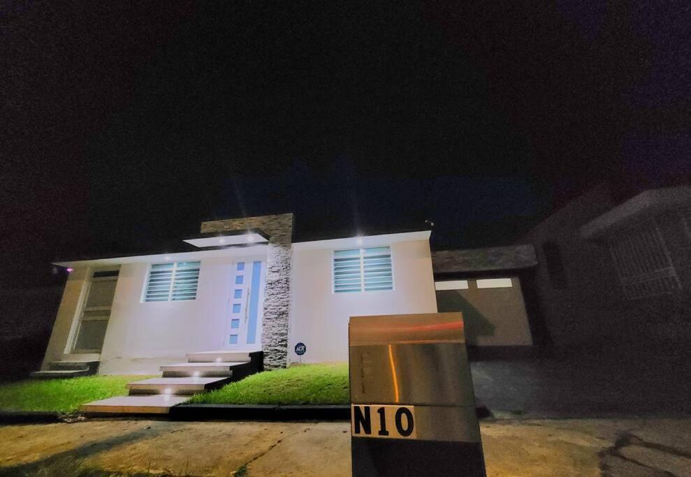 una casa blanca con un cartel delante de ella por la noche en Luxury 3-bedrooms near airport in San Juan, en San Juan