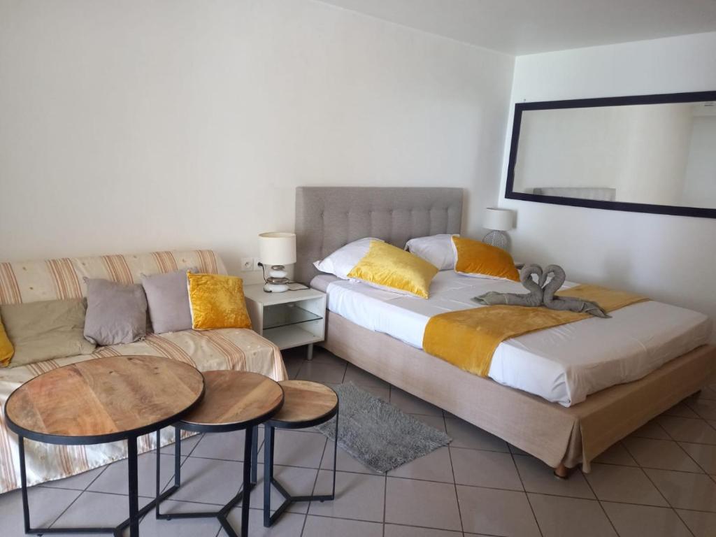 a bedroom with two beds and a couch at Grand studio de 41 m2 vue mer citerne in Le Gosier