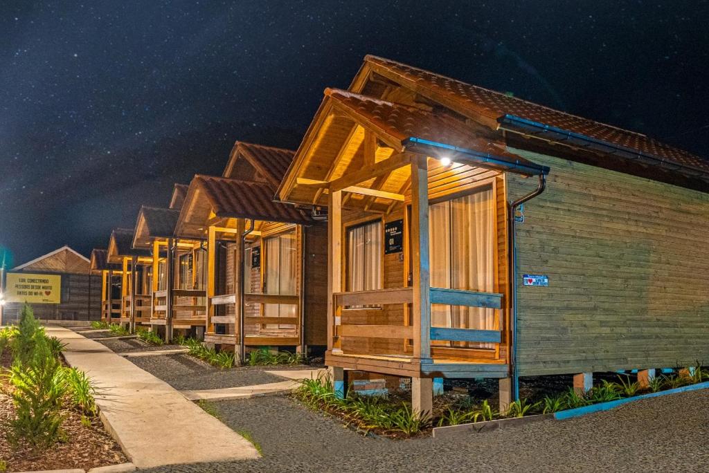 a row of wooden cabins in a row at night at POUSADA 05 LUAS URUBICI in Urubici