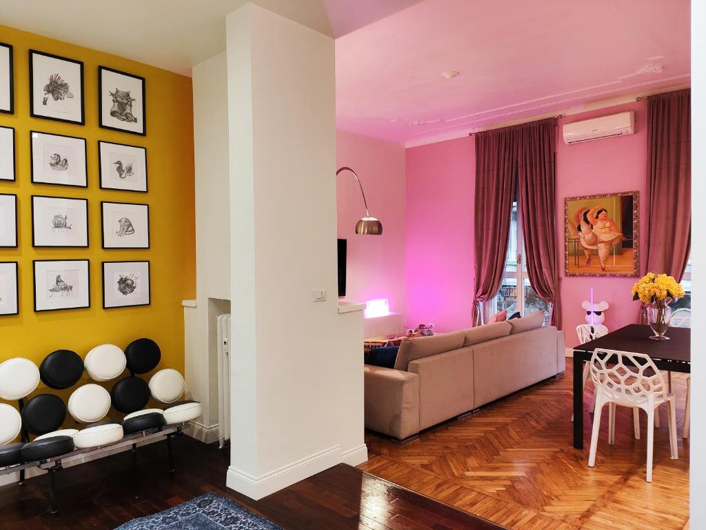 a living room with a couch and a table at Designed Pop Apartment 2 Bedrooms, 2 Baths in Milan Center - WiFi, AC, steps from Subway M1 and M2, Central Station and Airport connected in Milan