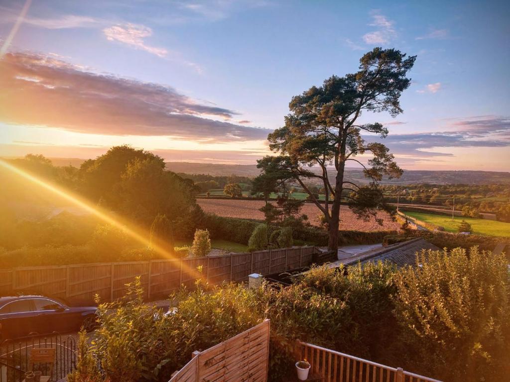 Our beautiful large Suite room with a Double bath with Shower ensuite - It has a full Kitchen boasting stunning views over the Axe Valley - Only 3 miles from Lyme Regis, River Cottage HQ & Charmouth - Comes with free private parking في أكسمنستر: منظر الغروب من حديقة المنزل