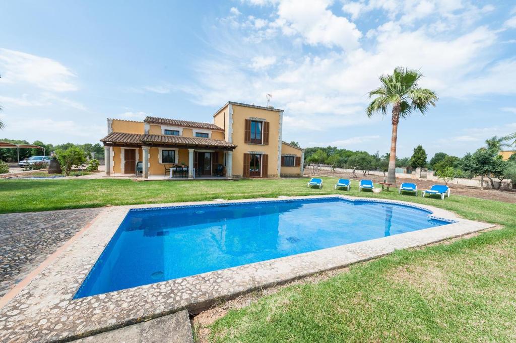 Villa con piscina frente a una casa en Ca Na Granada, en Muro