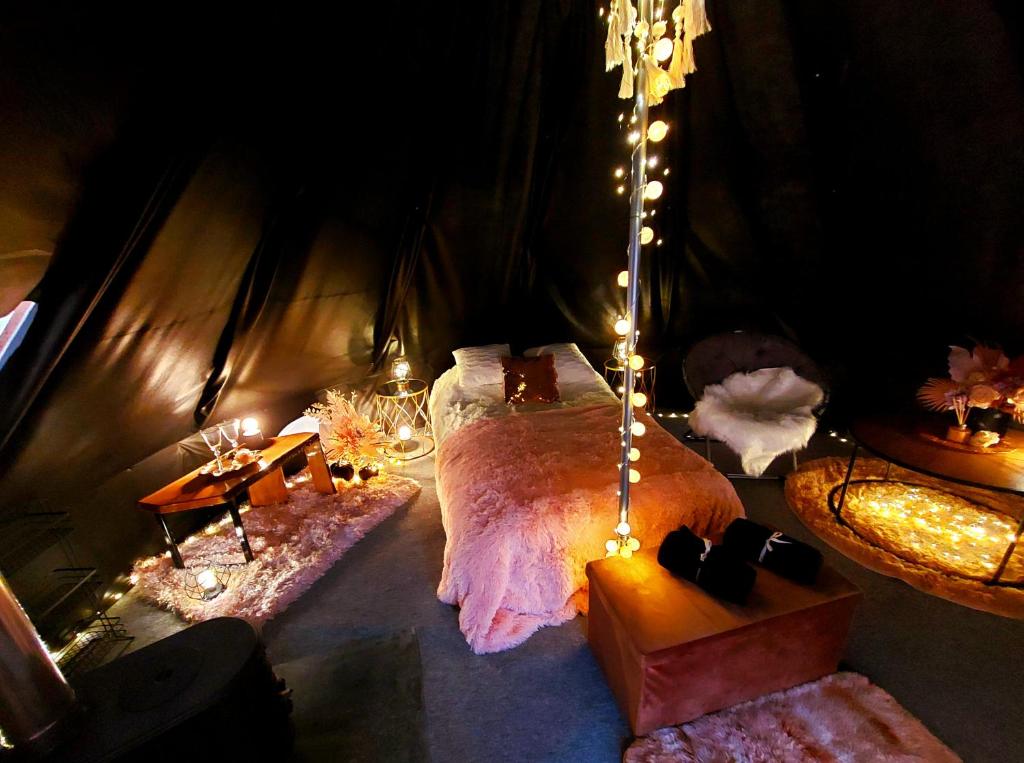 a room with a bed in a tent with lights at Glamping in - luxury tent 