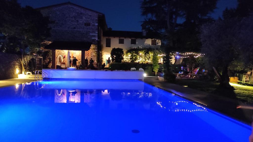 a swimming pool lit up at night with blue lights at Casa Tonello Zugliano in Zugliano