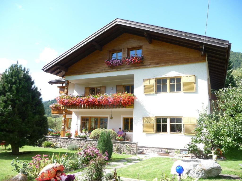 a white house with flowers in the yard at Haus am Park in Rasùn di Sotto