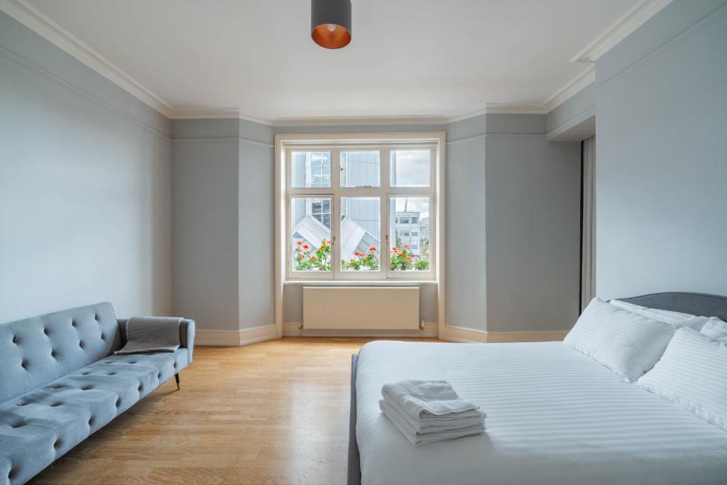 a white bedroom with a bed and a window at Bright Space in the Heart of London in London