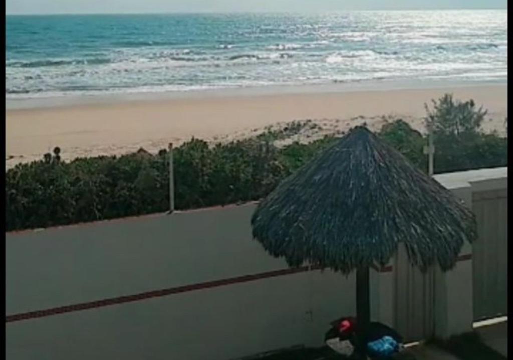 - Vistas a la playa con sombrilla en CASA DE PRAIA (PE NA AREIA), en Caponga