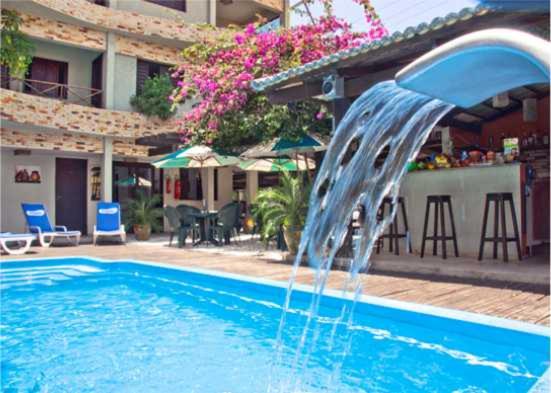 a water fountain in a swimming pool in front of a building at Pousada Beija Flor in Natal