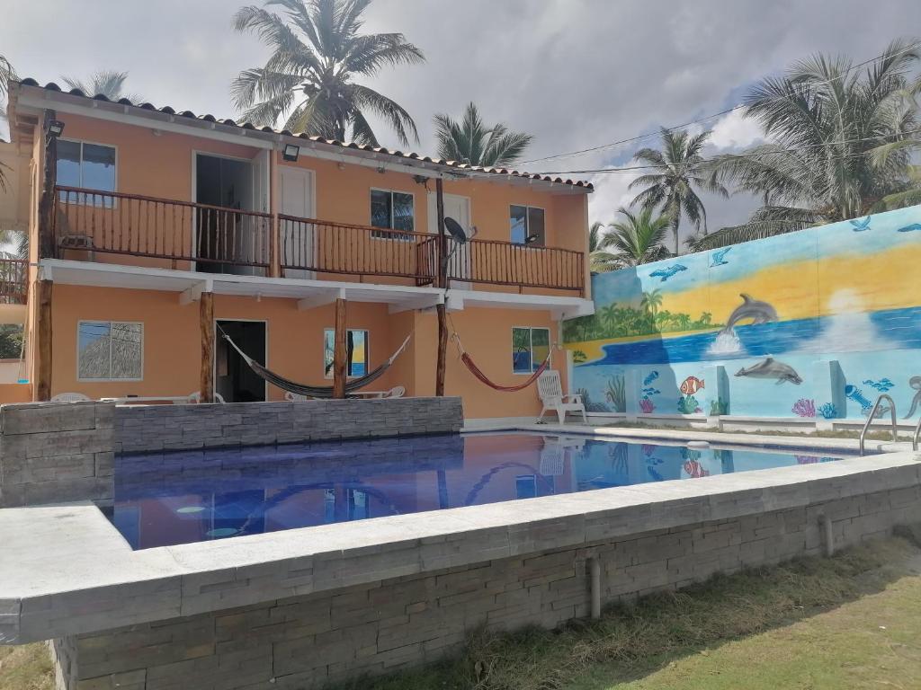 ein Haus mit einem Pool vor einem Gebäude in der Unterkunft Cabaña frente al mar en moñitos córdoba in Moñitos