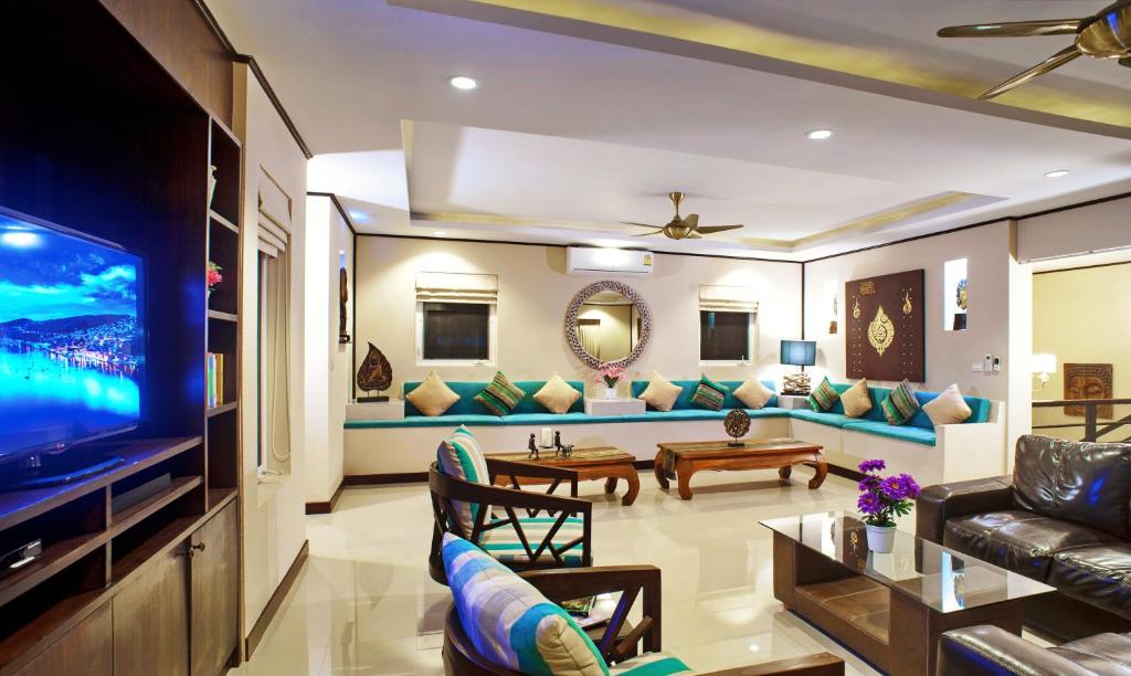 a living room with a couch and a tv at Samui Sunrise Seaview Villa in Chaweng