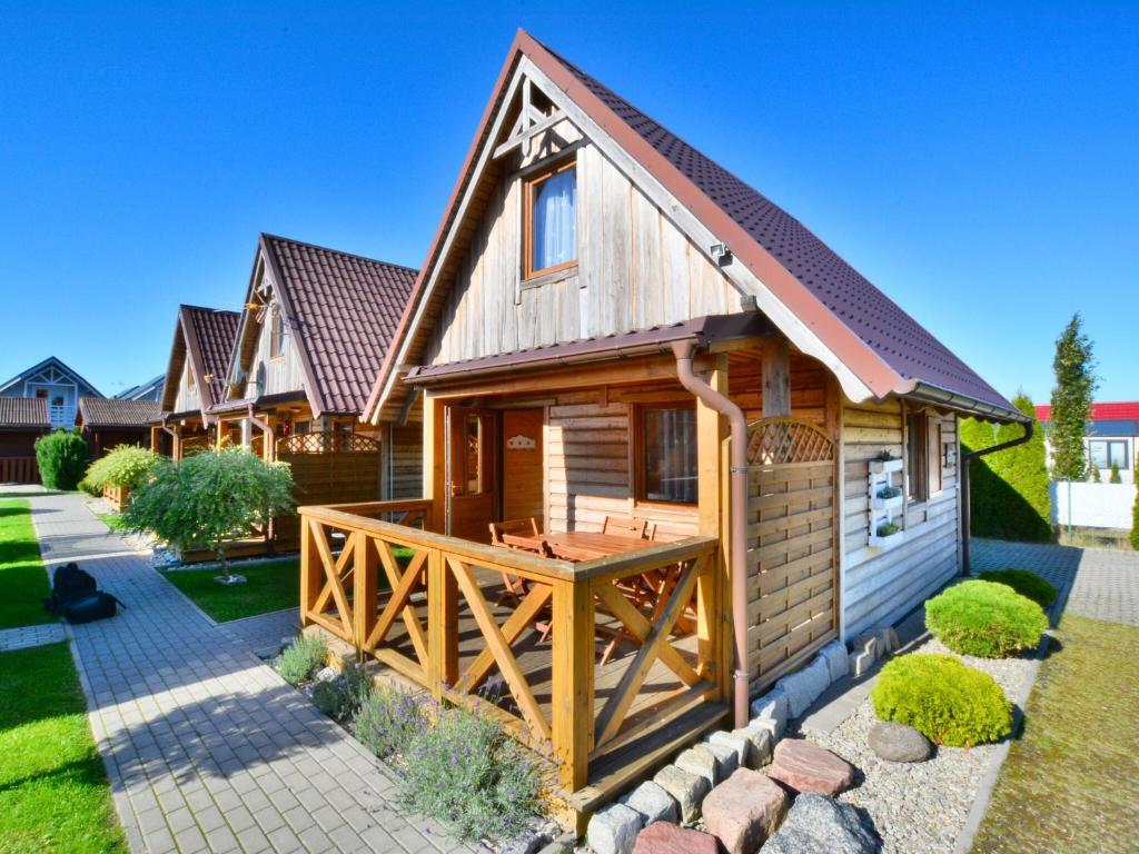 a log home with a deck and a house at Holiday home in Ustronie Morskie with a playground in Ustronie Morskie