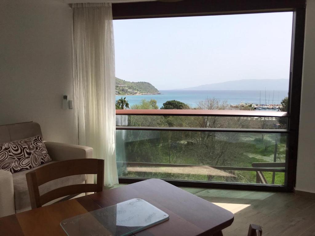 a living room with a table and a large window at Leman Apart in Bodrum City