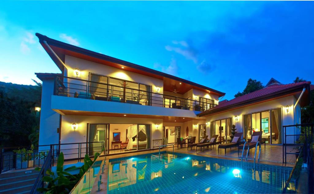 a villa with a swimming pool at night at Samui Sunrise Seaview Villa in Chaweng