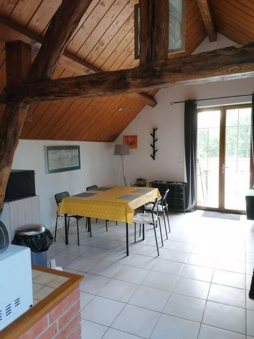 a dining room with a yellow table and chairs at Studio tout confort parking gratuit proche Paris in Briis-sous-Forges