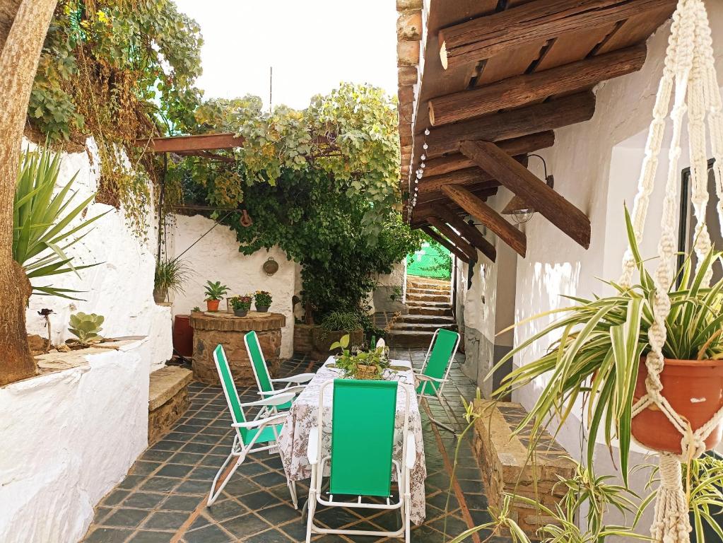 un patio con mesa, sillas y plantas en La Era de San Blas, en Fuentes de León