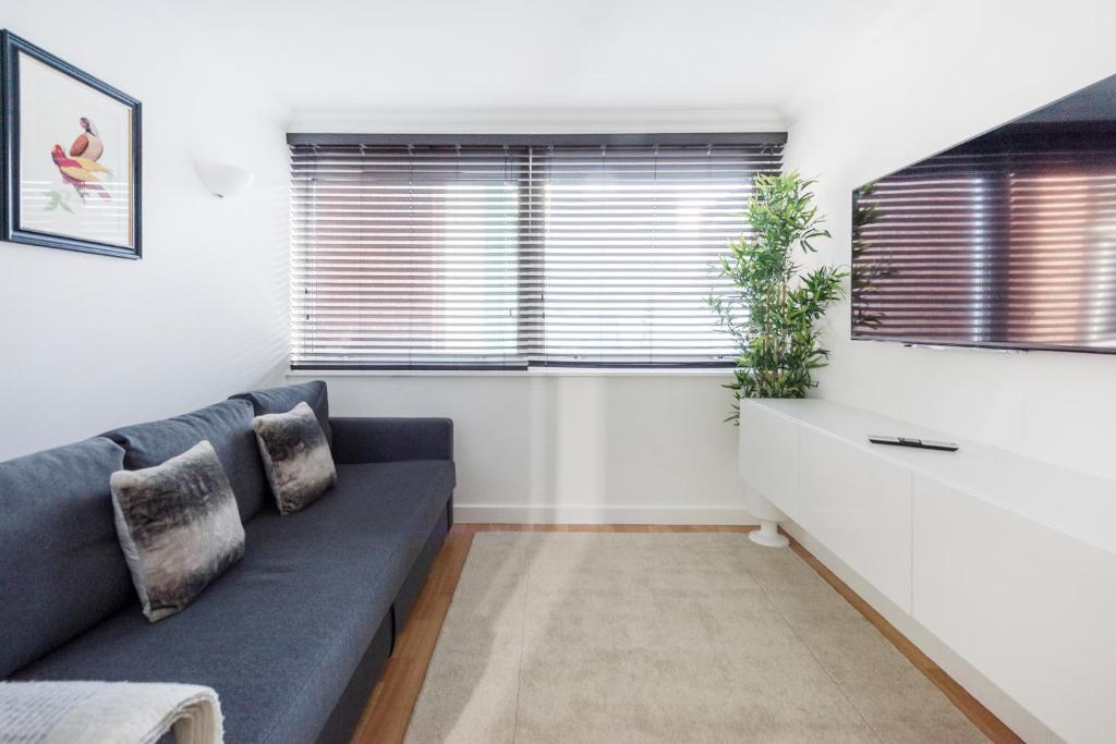 a living room with a blue couch and a window at Stunning 2 bedroom next to City Centre in Liverpool