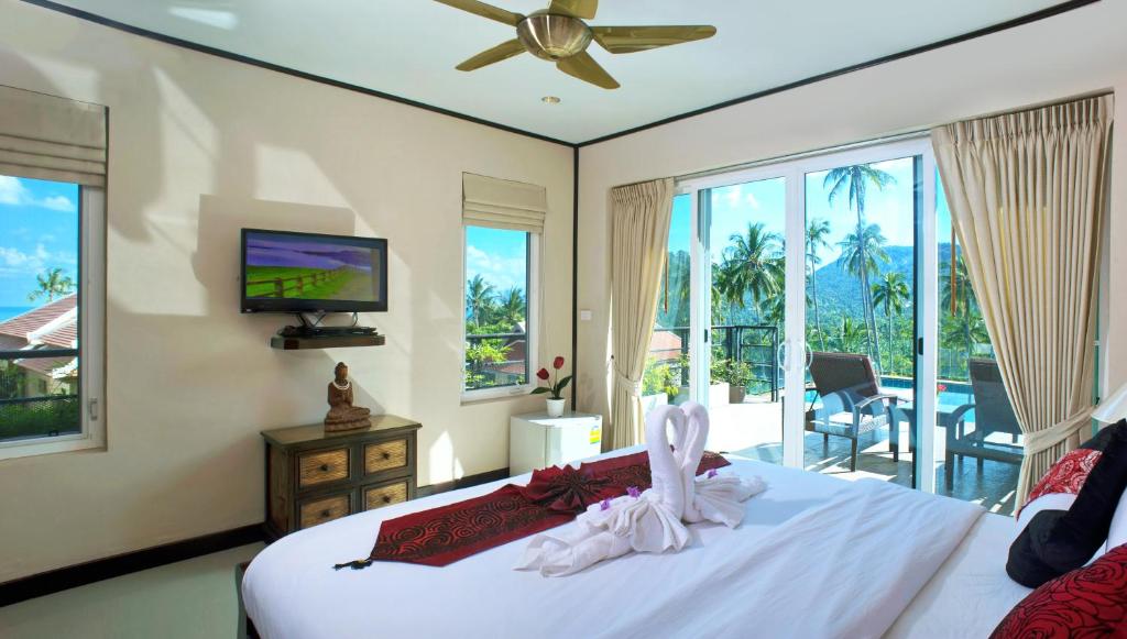 a bedroom with a bed with a television and a balcony at Samui Sunrise Seaview Villa in Chaweng