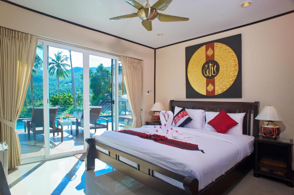 a bedroom with a bed with a ceiling fan at Samui Sunrise Seaview Villa in Chaweng