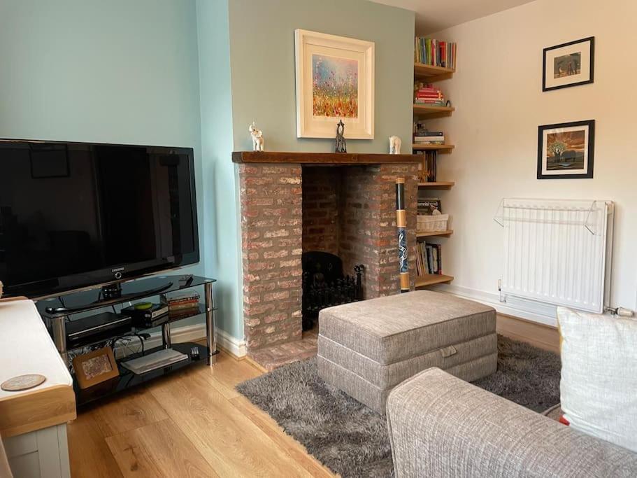 a living room with a television and a fireplace at Beautiful home perfect for families&professionals in Nantwich