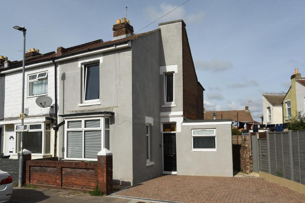 a white house with a brick driveway at Fully Refurbed : DRIVEWAY : HotTub : Central Location in Portsmouth