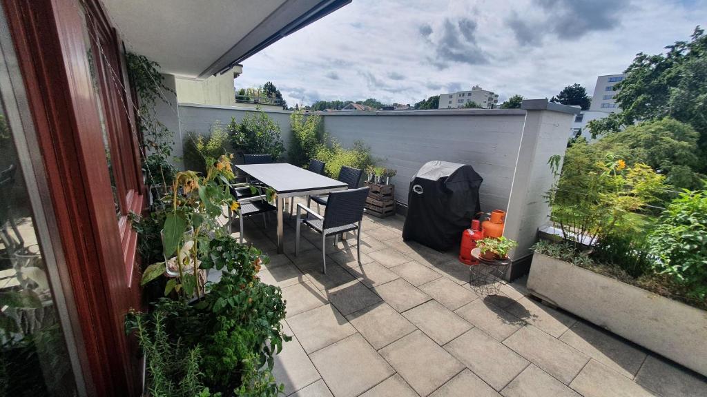 een patio met een tafel, stoelen en planten bij COSI - Komfortables Privatzimmer mit grosser Terrasse und Parkplatz in Kreuzlingen