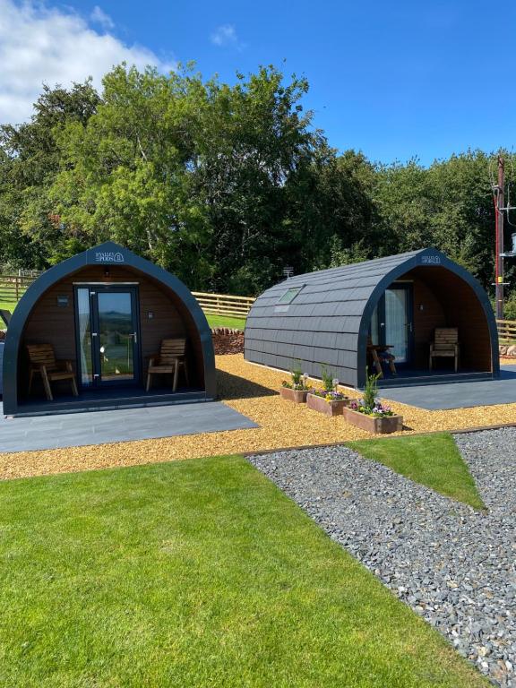 un grande edificio a forma di cupola con sedie sull'erba di Craigend Farm Holiday Pods - The Curly Coo a Dumfries