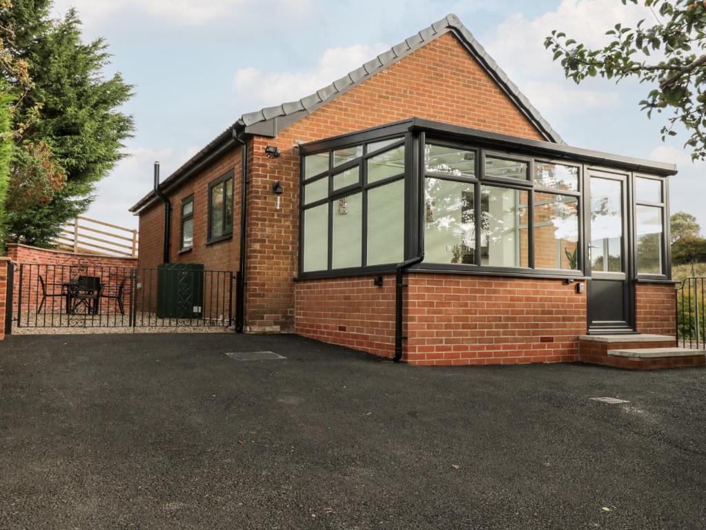 a brick house with large glass windows at Foulsyke Farm Bungalow in Saltburn-by-the-Sea