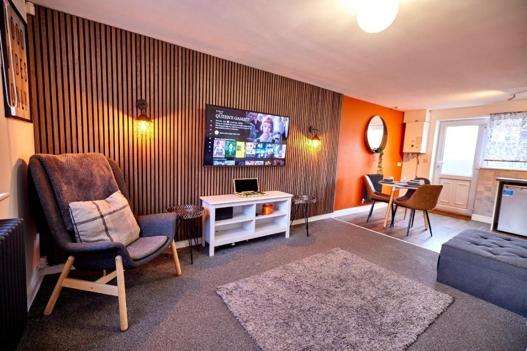 a living room with a chair and a tv at Willoughby House Beeston Nottingham in Nottingham