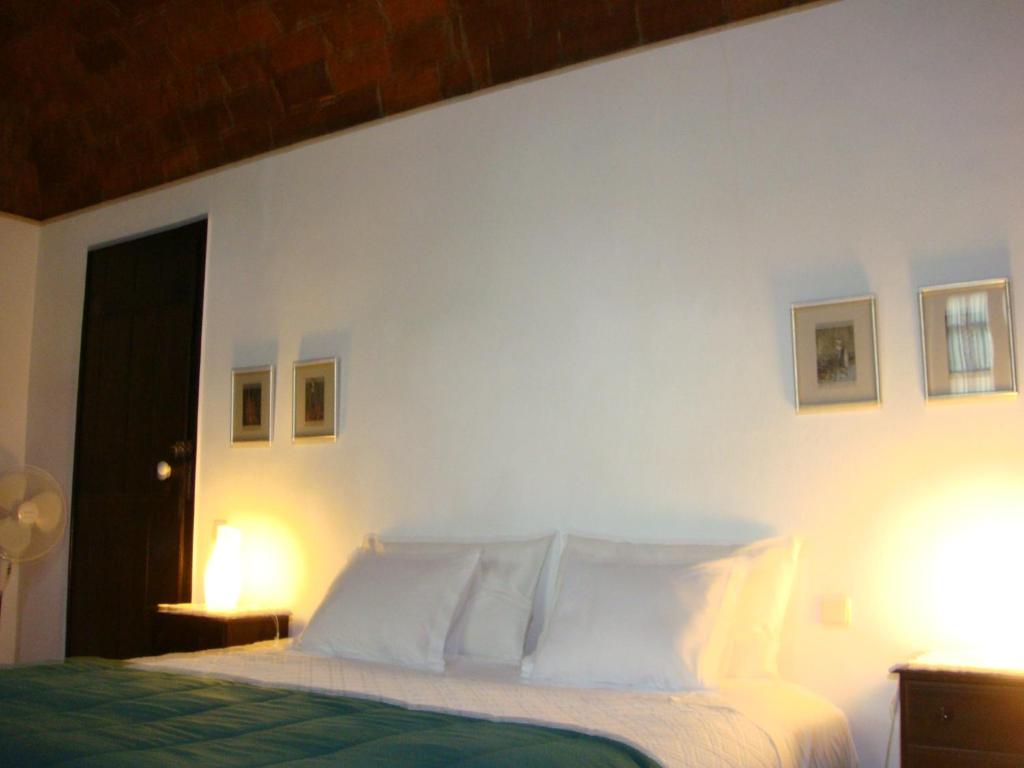 Dormitorio blanco con cama con almohadas blancas en Quarto Duplo - Monte dos Arneiros, en Lavre