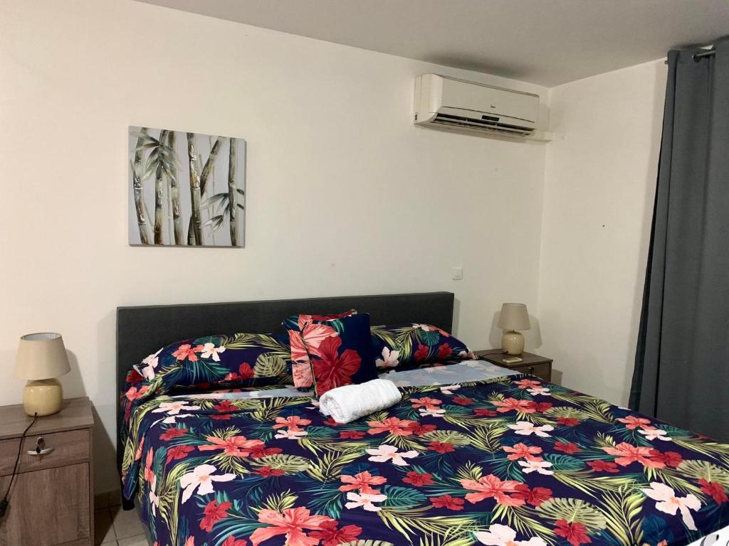 una camera da letto con un letto con un piumone colorato di Studio Papeete Lodge - Kaoha Nui a Papeete