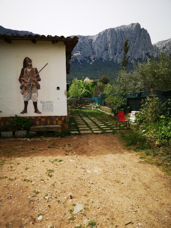 a painting of a man with a gun on the side of a building at Pinnettu sardo casa di campagna in ecosistema insetti e animaletti simpatici in condivisione,Leggere attentamente Prima di prenotare in Oliena