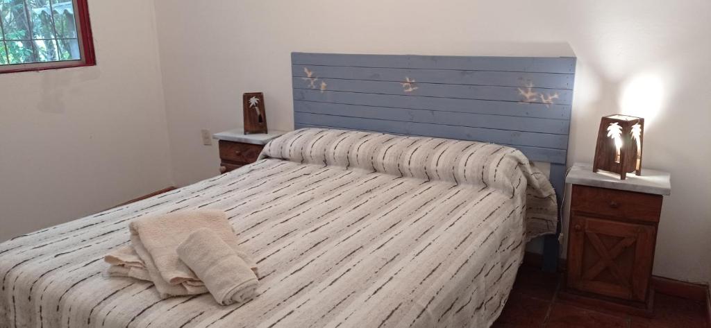 1 dormitorio con 1 cama con cabecero azul en Cabañas del Pilar en Pilar