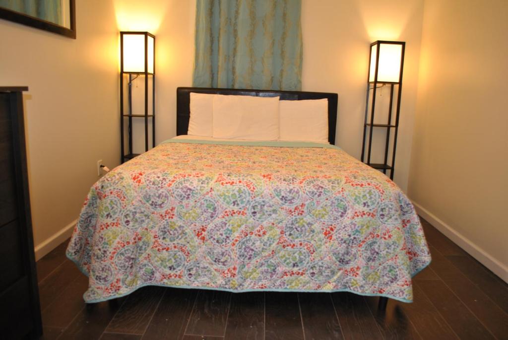 um quarto com uma cama com uma colcha colorida em EWR AIRPORT MOTELCASA Guest House Newark NJ em Newark