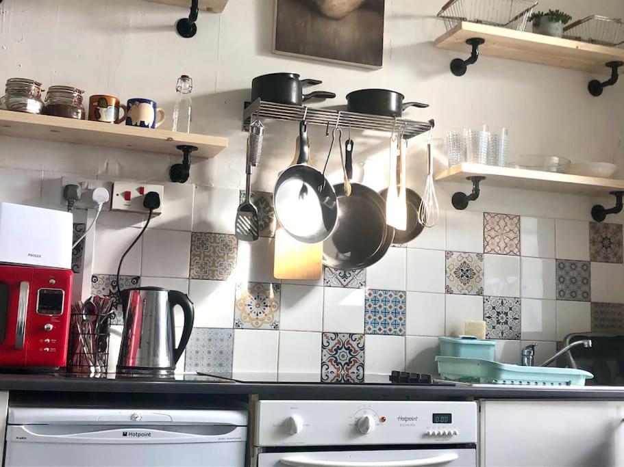 een keuken met potten en pannen aan de muur bij City Studio in Swansea