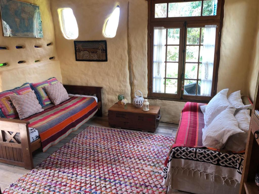 a bedroom with a bed and a couch and windows at Todo se transforma in Cuchilla Alta