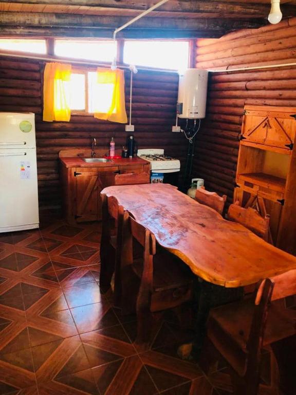 a kitchen with a large wooden table in a room at Cabañas Achalay in Valle Hermoso