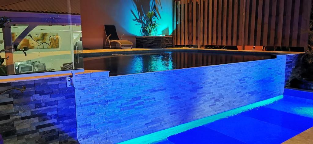 a swimming pool in a house with blue lighting at Résidence B&L Lagon : T3 Alizés in Sainte-Luce