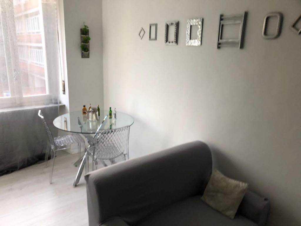 een woonkamer met een bank en een glazen tafel bij Appartamento Farfalla Sara pala inalpi in Turijn