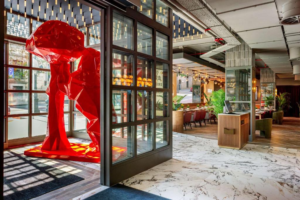 a large red sculpture is on display in a building at Radisson RED Madrid in Madrid