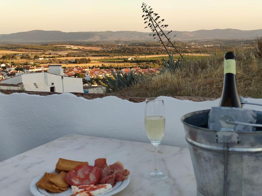 a plate of food and a glass of wine on a table at Casa da Muralha in Estremoz