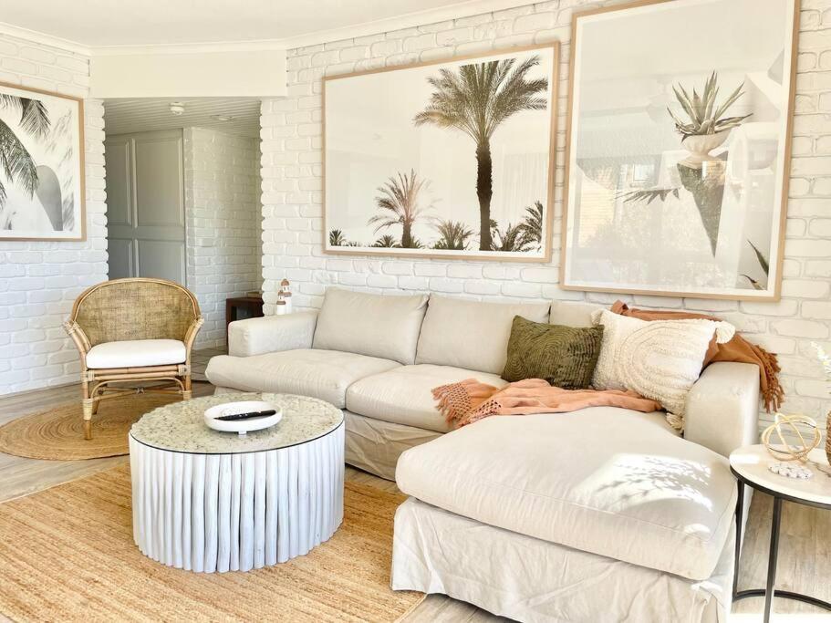 a living room with a couch and a coffee table at Surf Haven opposite Clarkes Beach pool walk to CBD in Byron Bay