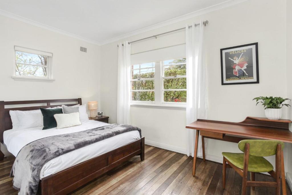 1 dormitorio con cama, escritorio y ventana en Katoomba Getaway 3 Bedroom Villa en Katoomba